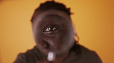 Büyüteçle bakan Afrikalı bir adamın portresi.