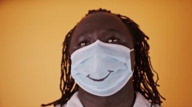 Yüzünde çizgili gülümsemesi olan Afrikalı adam umutla gökyüzüne bakıyor.
