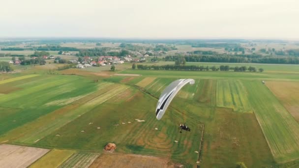 LuchtDrone uitzicht op Paramotor Tandem met plezier glijden en vliegen in de lucht — Stockvideo
