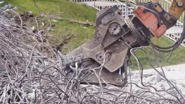 Maquinaria de excavadora de trituradora hidráulica que destruye cables y tuberías de un puente. De cerca. — Vídeo de stock
