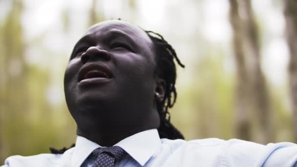 Gros plan d'un homme d'affaires africain faisant une pause dans le parc. Mouvement lent — Video