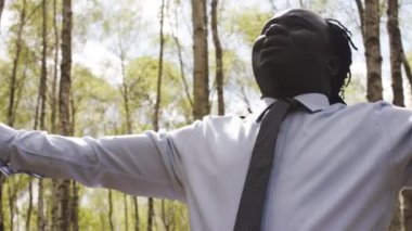 Siyahlar yaşıyor. Parkta dua eden ellerini uzatmış Afrikalı işadamı.