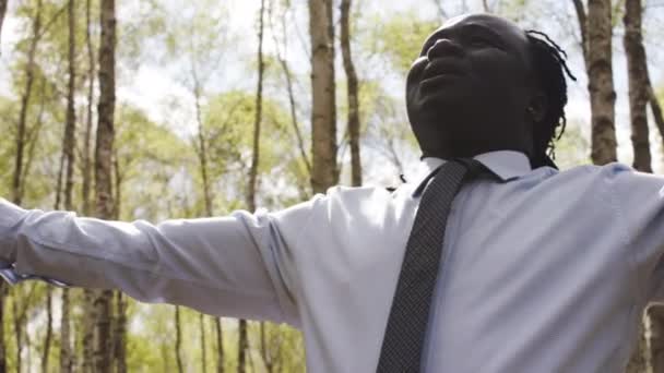 Los negros viven metros. Empresario africano con las manos extendidas rezando en el parque — Vídeo de stock