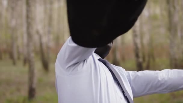 Uomo d'affari africano che celebra il successo nella natura mentre gira il suo vestito intorno — Video Stock
