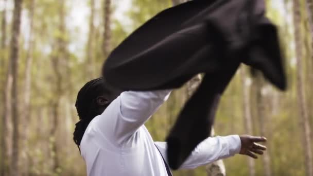 Afrikansk affärsman firar framgång i naturen samtidigt snurrar sin kostym runt — Stockvideo