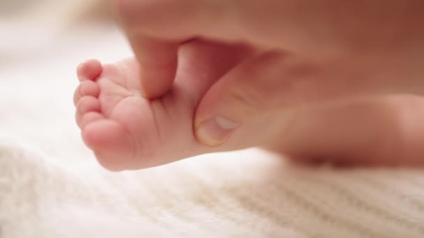 Mãe massagear e cócegas pequenos pés de bebê. close up slow motion shot — Vídeo de Stock