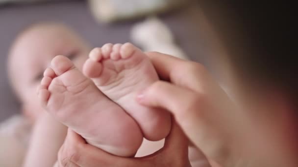 Moeder masseren en kietelen kleine baby voeten. close-up slow motion schot — Stockvideo