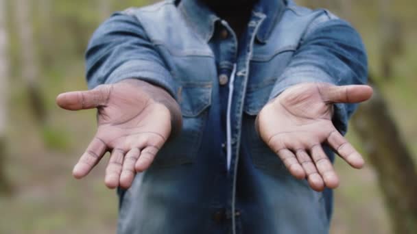 Afrikaanse man die de palm van zijn handen laat zien. Close-up slow motion schot — Stockvideo