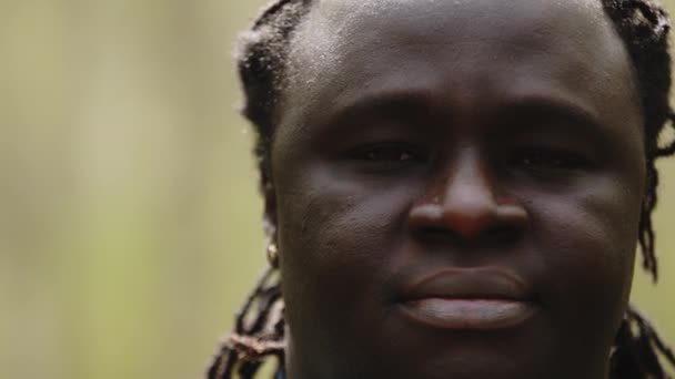 Nahaufnahme eines afrikanischen Mannes, der seine Augen öffnet und in die Kamera blickt — Stockvideo
