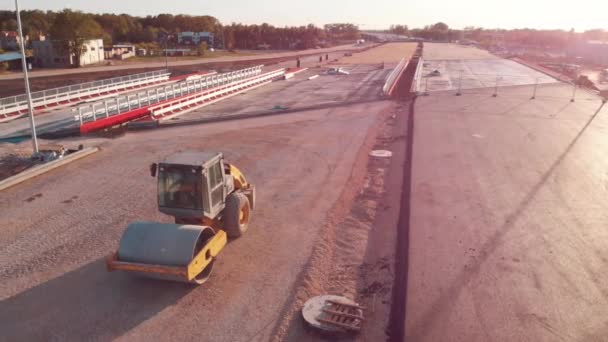 Yeni yol yapım günbatımında asfalt kaldırım makinesi ve buharlı yol silindiri — Stok video