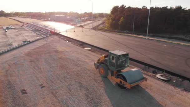 Maszyna asfalt brukarz i parowe rolki drogowe podczas budowy nowej drogi zachód słońca — Wideo stockowe