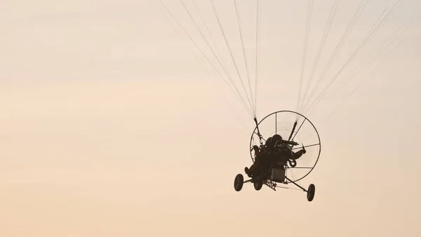 Silueta del tándem paramotor deslizándose y volando en el aire. Copiar espacio — Foto de Stock