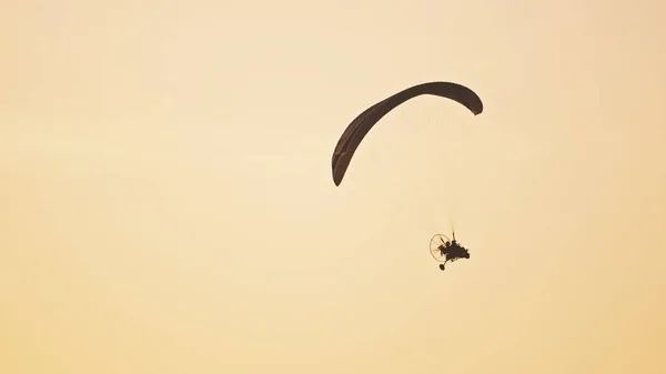 Silueta del tándem paramotor deslizándose y volando en el aire. Copiar espacio — Foto de Stock