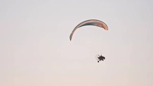 A Paramotor Tandem sziluettje suhan és repül a levegőben. Fénymásolási hely — Stock Fotó