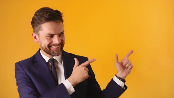 Portrait of satisfied handsome guy in formal outfit pointing on empty space — Stock Photo, Image