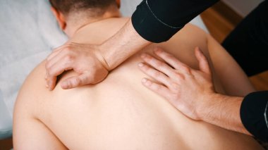 Kayropraktik tedavi - doktor hastaya masaj yapıyor - elleriyle sırtına bastırıyor..