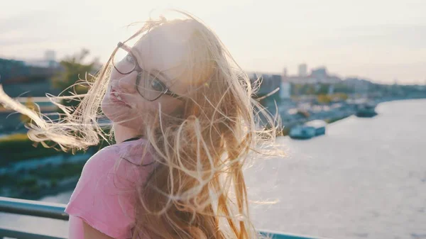 Portret van een gelukkige vrouw op de brug, wind speelt met haar lange haar — Stockfoto