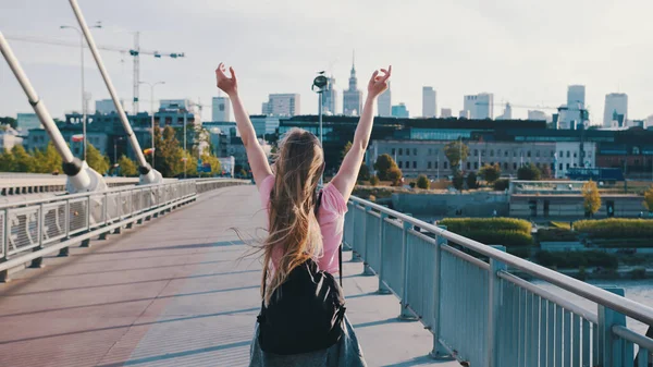 Sırt çantalı genç bir kadın. Özgürlük kavramı. Yükselen eller havaya. Yayalar yukarı, çekim devam.