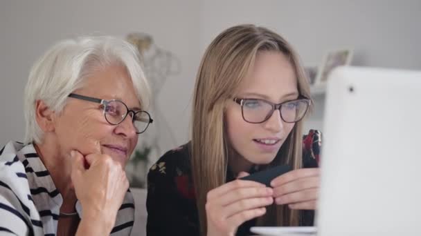 Enkelin hilft ihrer Großmutter beim Online-Einkauf. Waren online bestellen