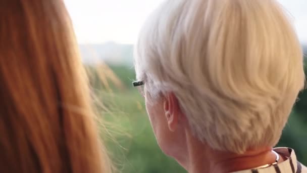 Close-up shot van senior moeder en volwassen dochter kijken in elkaar op het balkon — Stockvideo