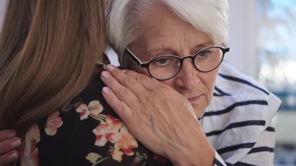 Een jonge vrouw die een oudere vrouw omarmt. Verdriet en kralen nieuws, empathie concept — Stockvideo