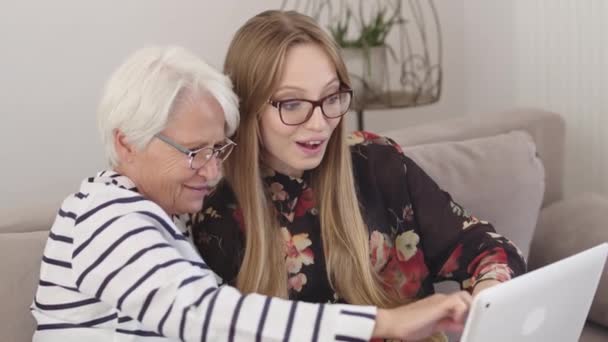 Oma en oma kijken naar oude foto 's op de tablet. — Stockvideo