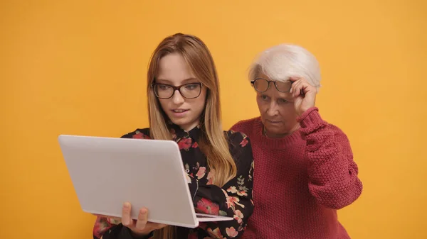Mujer joven explicando a una señora mayor cómo utilizar el ordenador portátil. — Foto de Stock