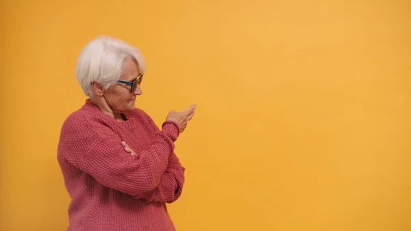 Mujer mayor de pelo gris con gafas de sol señalando los dedos en el espacio vacío — Foto de Stock