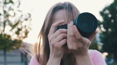Genç sarışın fotoğrafçı, video kamerasının görüntüsüne bakıyor.