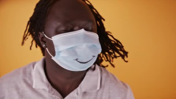 Afrikansk man med ansiktsmask skakar flätat hår — Stockvideo