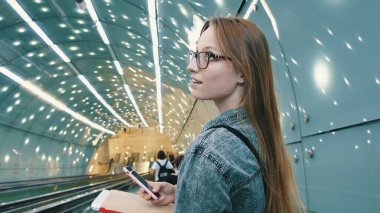 Tünelde kitapları ve akıllı telefonu olan genç bir kadının fütüristik portresi