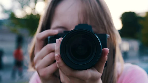 Fotografera utomhus. Kvinnlig fotograf tittar genom sökaren av hennes dslr kamera — Stockfoto