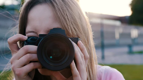 Fotografera utomhus. Kvinnlig fotograf tittar genom sökaren av hennes dslr kamera — Stockfoto