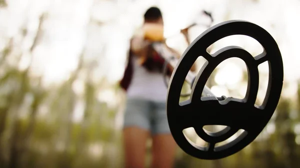 Mujer joven arqueóloga usando detector de metales en el bosque. Vista de ángulo bajo. — Foto de Stock