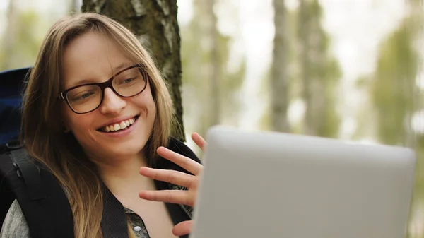 Молодая туристка отдыхает в парке и делает видеозвонок на планшете — стоковое фото