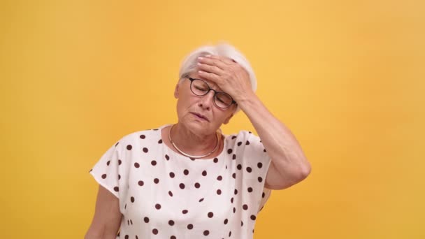 Seniorenvrouw die hoofdpijn heeft. Hand op haar voorhoofd. — Stockvideo