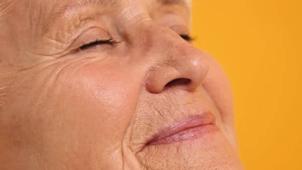 Close-up tiro do rosto da mulher idosa com sorriso solitário — Fotografia de Stock