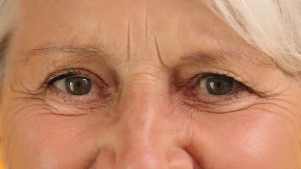 Macro inyección de un ojo verde con arrugas de una mujer anciana —  Fotos de Stock