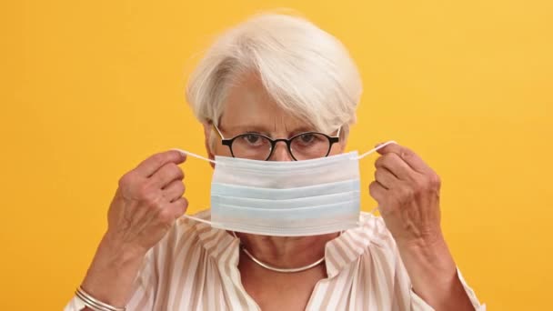 Covid19 prevención. Mujer mayor que se pone máscara médica en la cara — Vídeos de Stock