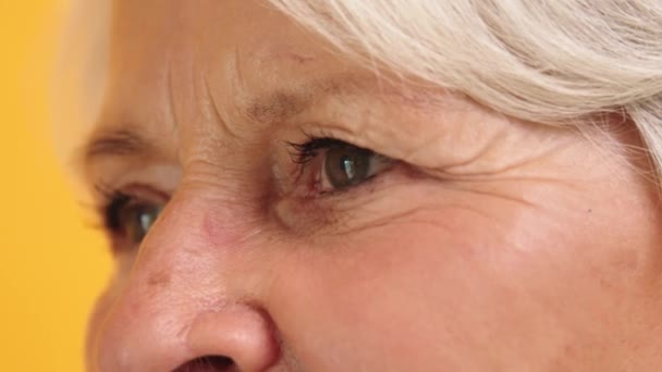 Макро знімок зеленого ока зі зморшками літньої жінки. Вид збоку — стокове відео
