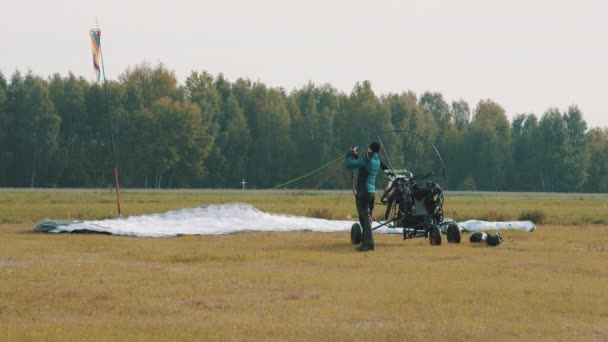 Parapente homem preparando paraquedas para deslizamento paramotor tandem — Vídeo de Stock