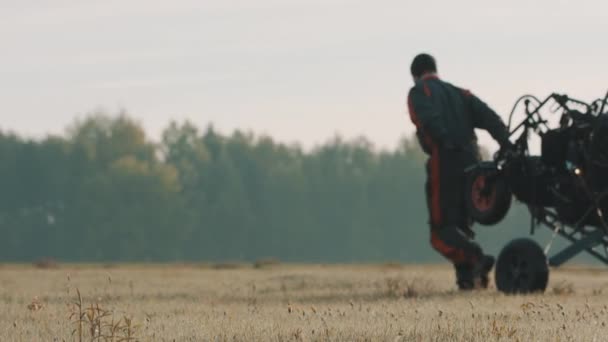 Hombre tirando del paramotor en tándem sobre el prado. Colores otoñales — Vídeo de stock