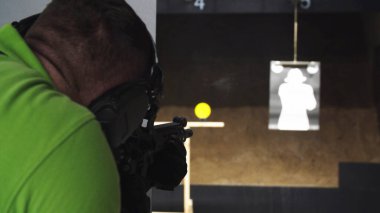 Yetişkinler atış poligonunda bir saldırı tüfeği yüklüyor..