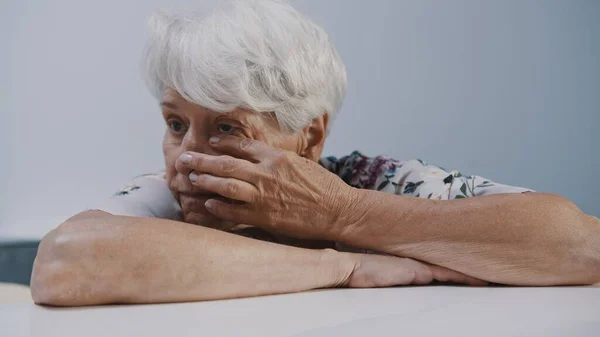 Печальная старуха плачет в одиночестве в домашнем карантине. Уязвимые групповые проблемы — стоковое фото