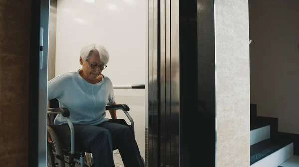 Пожилая женщина-инвалид на лифте в инвалидном кресле — стоковое фото