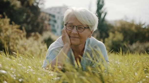 Senior femme aux cheveux gris profitant de la journée ensoleillée d'automne dans le parc — Video