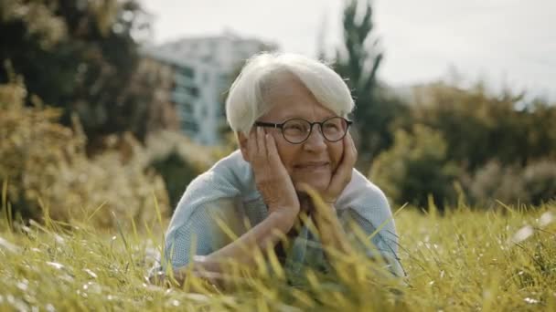 Senior feliz mujer de pelo gris disfrutando del soleado día de otoño en el parque — Vídeos de Stock