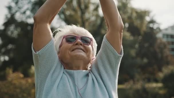 Senior aposentado mulher desfrutando de liberdade de aposentadoria. Mãos estendidas no parque, de perto — Vídeo de Stock