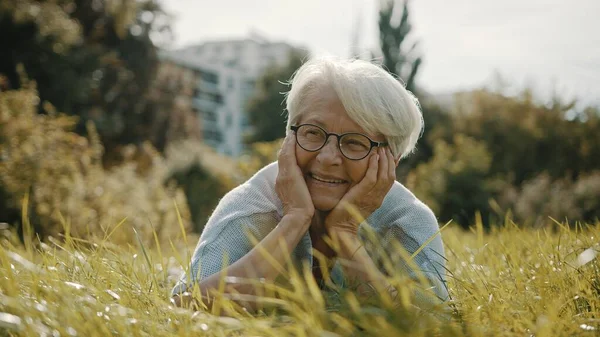 Senior retired woman enjoying the sunny autumn day in the park — Stock Photo, Image