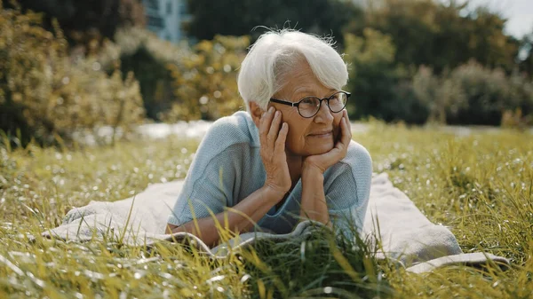 Seniorin genießt den sonnigen Herbsttag im Park — Stockfoto